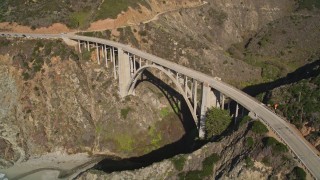 AXSF16_071 - 5K aerial stock footage of approaching and orbiting the Bixby Creek Bridge above coastal cliffs, Big Sur, California