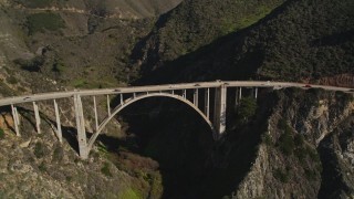 AXSF16_072 - 5K aerial stock footage of light traffic on the Bixby Creek Bridge above coastal cliffs, Big Sur, California