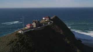 AXSF16_087 - 5K aerial stock footage flying by Point Sur Lighthouse buildings atop a coastal cliff, Big Sur, California