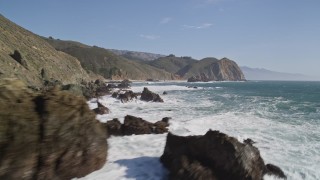 AXSF16_100 - 5K aerial stock footage tilt from ocean to reveal coastal rock formations below cliffs, Big Sur, California
