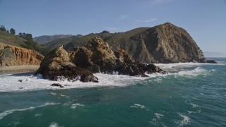 AXSF16_101 - 5K aerial stock footage tilt from the ocean to reveal rock formations near coastal cliffs, Big Sur, California