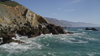 AXSF16_102 - 5K aerial stock footage fly low over waves slamming into coastal cliffs, Big Sur, California