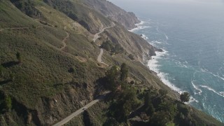 AXSF16_112 - 5K aerial stock footage tilt up Highway 1 with light traffic above coastal cliffs, Big Sur, California