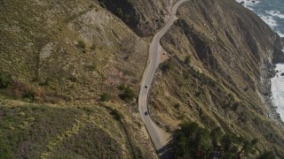 AXSF16_113 - 5K aerial stock footage of flying over the Highway 1 road atop coastal cliffs, tilt to cars, Big Sur, California