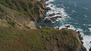 AXSF16_117 - 5K aerial stock footage tilt from waves crashing and approach cliffs on the coast, then tilt back down to the water, Big Sur, California