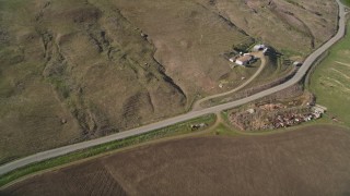 AXSF16_148 - 5K aerial stock footage fly away from farmhouse, country road, hills, and farm fields in San Luis Obispo County, California