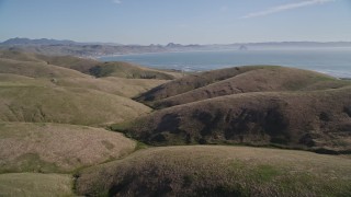 AXSF16_149 - 5K aerial stock footage of flying over hills, revealing the coastline in Cayucos, California