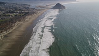 AXSF16_150 - 5K aerial stock footage of tilting from Morrow Strand Beach revealing Morro Rock, Morro Bay, California