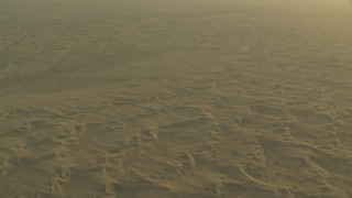 CAP_001_007 - HD stock footage aerial video of flying over hazy desert sand dunes at sunrise, Al Gharbia, Abu Dhabi, UAE