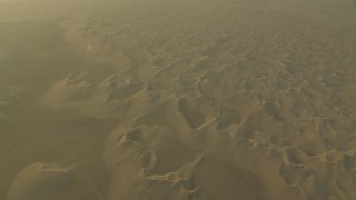 CAP_001_012 - HD stock footage aerial video of orbit and fly away from desert sand dunes at sunrise in Al Gharbia, Abu Dhabi, UAE