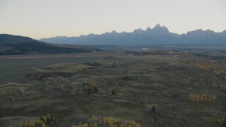 CAP_002_001 - HD stock footage aerial video fly over hills toward mountains, Jackson Hole, Wyoming, twilight