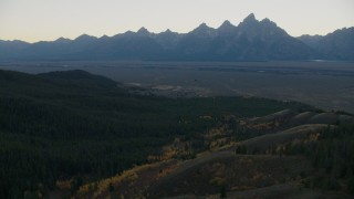 CAP_002_009 - HD stock footage aerial video of mountains seen from evergreen forest, Jackson Hole, Wyoming, twilight