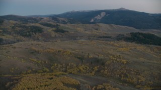 CAP_002_014 - HD stock footage aerial video flyby sparse autumn trees on hills in Jackson Hole, Wyoming, twilight