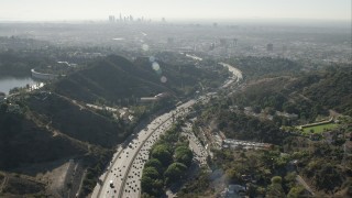 CAP_004_008 - HD stock footage aerial video of tilt from freeway in Hollywood Hills to reveal Downtown Los Angeles skyline, California