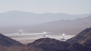 CAP_005_016 - HD stock footage aerial video of solar towers at Ivanpah Solar Electric Generating System seen from mountains, Mojave Desert, California