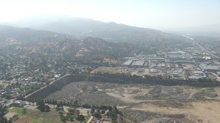 CAP_006_003 - HD stock footage aerial video of warehouse buildings and a large landfill area in Sun Valley, California