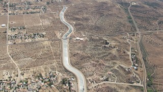 CAP_006_006 - HD stock footage aerial video flyby rural desert homes around the California Aqueduct in Palmdale, California