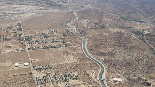 CAP_006_007 - HD stock footage aerial video pass rural homes and desert around the California Aqueduct in Palmdale, California
