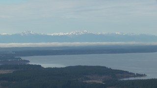 CAP_009_007 - HD stock footage aerial video of the snowy Olympic Mountain range seen from Puget Sound, Washington
