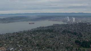 CAP_009_017 - HD stock footage aerial video fly over homes to approach cargo ship in Commencement Bay, Tacoma, Washington