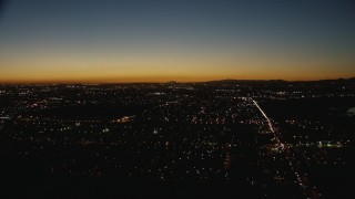 CAP_010_008 - HD stock footage aerial video tilt from residential neighborhoods to reveal the Downtown Los Angeles city skyline at twilight, California