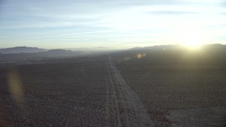 CAP_011_001 - HD stock footage aerial video of following power lines through the desert to approach Daggett, California at sunrise