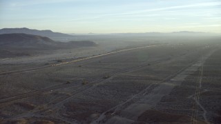 CAP_011_003 - HD stock footage aerial video approach I-40 and a train in the desert in Daggett, California at sunrise