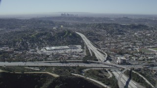 CAP_012_011 - HD stock footage aerial video of the 2 and 134 freeway interchange in Glendale, California, Downtown Los Angeles skyline in background