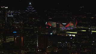CAP_013_004 - HD stock footage aerial video of Mercedes Benz Stadium while flying by skyscraper at night, Downtown Atlanta, Georgia