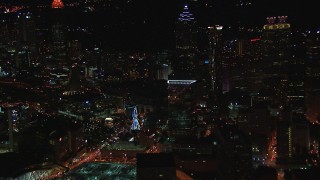 CAP_013_028 - HD stock footage aerial video of flying away from city buildings and skyscrapers near Ferris wheel at night, Downtown Atlanta, Georgia