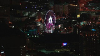 CAP_013_061 - HD stock footage aerial video of flying by a Ferris wheel at nighttime, Downtown Atlanta, Georgia