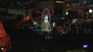 CAP_013_062 - HD stock footage aerial video of flying by the top of a skyscraper to reveal a Ferris wheel at nighttime, Downtown Atlanta, Georgia