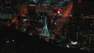 CAP_013_063 - HD stock footage aerial video of flying away from a Ferris wheel at nighttime, reveal skyscraper, Downtown Atlanta, Georgia