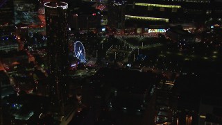 CAP_013_064 - HD stock footage aerial video of a Ferris wheel at nighttime while passing skyscrapers, Downtown Atlanta, Georgia