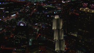 CAP_013_065 - HD stock footage aerial video of a Ferris wheel at nighttime while passing a skyscraper, Downtown Atlanta, Georgia