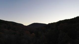 CAP_014_015 - 2.7K stock footage aerial video ascend over forest for view of distant mountains at sunset, Chimney Rock, North Carolina