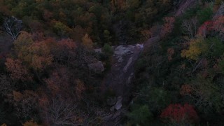 CAP_014_016 - 2.7K stock footage aerial video a bird's eye view of a clifftop waterfall at sunset, Chimney Rock, North Carolina