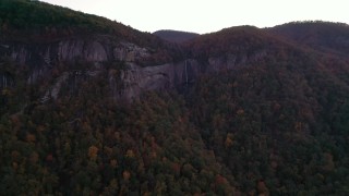 CAP_014_023 - 2.7K stock footage aerial video a view of forest, mountains, and a clifftop waterfall at sunset, Chimney Rock, North Carolina