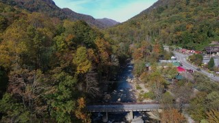 CAP_014_027 - 2.7K stock footage aerial video follow river over a bridge next to small town, Chimney Rock, North Carolina