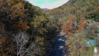 CAP_014_028 - 2.7K stock footage aerial video follow river surrounded by forest trees, Chimney Rock, North Carolina