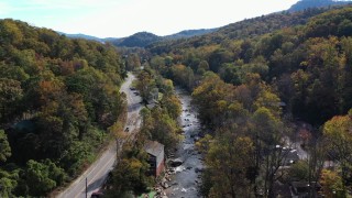 CAP_014_031 - 2.7K stock footage aerial video follow river beside a road through town, Chimney Rock, North Carolina
