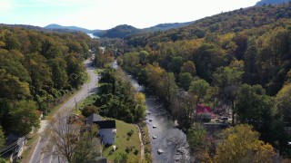 CAP_014_032 - 2.7K stock footage aerial video of flying over a river beside a road through a small town, Chimney Rock, North Carolina