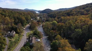 CAP_014_033 - 2.7K stock footage aerial video of flying over a river beside a road in a small town, Chimney Rock, North Carolina