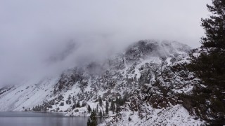 CAP_015_001 - 4K stock footage aerial video of snowy mountain slopes beside lake in Inyo National Forest, California