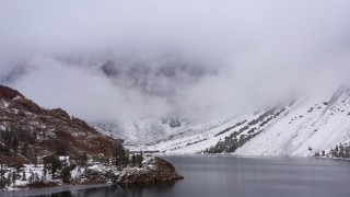 CAP_015_008 - 4K stock footage aerial video flying away from snowy mountain slopes by Ellery Lake, Inyo National Forest, California