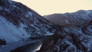 CAP_015_029 - 4K stock footage aerial video ascend with view of snowy Sierra Nevada Mountains by lake at sunset, Inyo National Forest, California