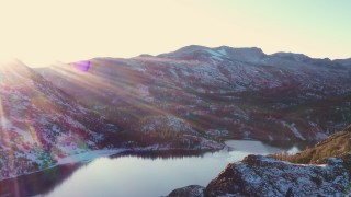 CAP_015_030 - 4K stock footage aerial video pan across snowy Sierra Nevada Mountains and lake at sunset, Inyo National Forest, California