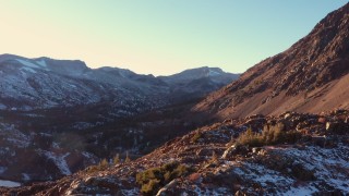 CAP_015_032 - 4K stock footage aerial video fly over rocky slope for wide view of mountain valley at sunset, Inyo National Forest, California