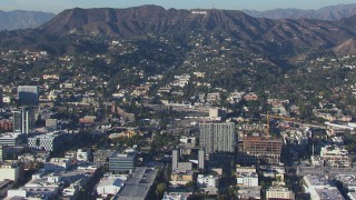 CAP_016_011 - HD stock footage aerial video orbit apartment buildings and college with view of the Hollywood Sign, California