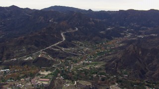 CAP_018_012 - HD stock footage aerial video of approaching mountains and road scarred by fire, Malibu, California